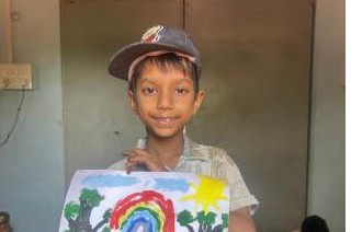 A boy holding up his rainbow painting
