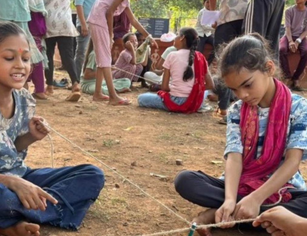 Children doing a string measuring activity outdoors